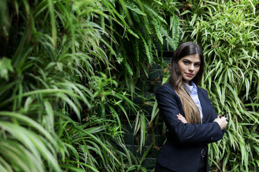 Porträt einer selbstbewussten jungen Geschäftsfrau, umgeben von Pflanzen - VABF01993