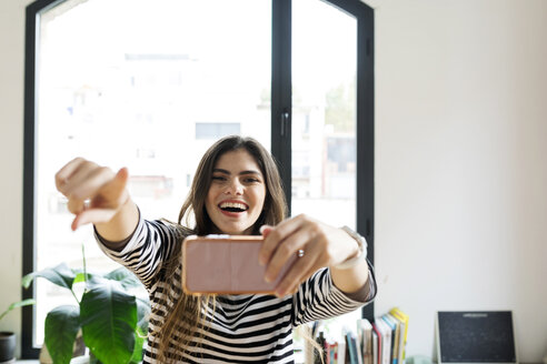 Glückliche junge Frau zu Hause, die ein Selfie macht - VABF02039