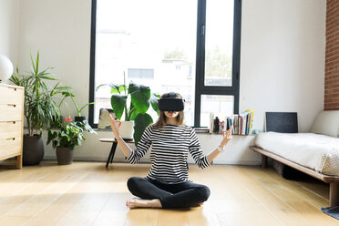 Young woman at home wearing VR glasses doing yoga - VABF02044