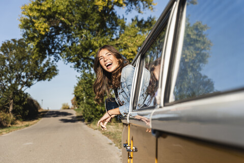 Hübsche Frau auf einer Autoreise mit ihrem Wohnmobil, Blick aus dem Autofenster, lizenzfreies Stockfoto