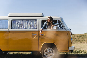 Pretty woman on a road trip with her camper, looking out of car window - UUF16131