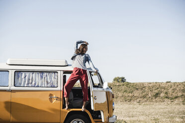 Pretty woman on a road trip with her camper, cheering, enjoying freedom - UUF16152