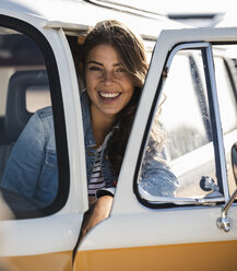Pretty woman on a road trip with her camper, looking out of car window - UUF16154