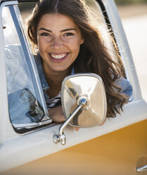 Pretty woman on a road trip with her camper, looking out of car window - UUF16155