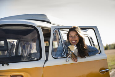 Pretty woman on a road trip with her camper, looking out of car window - UUF16157