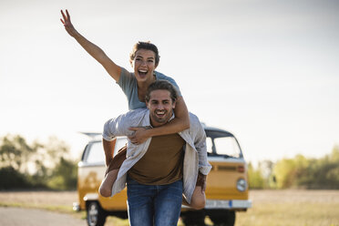 Glückliches Paar auf einem Roadtrip mit einem Wohnmobil, das so tut, als würde es auf der Straße fliegen - UUF16203