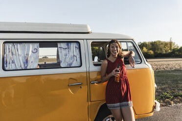 Pretty woman on a road trip with her camper, taking a break at sunset - UUF16243