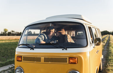 Happy couple sitting in their camper, kissing - UUF16260