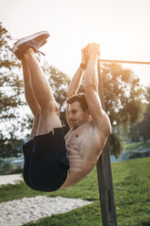 Sportlicher Mann beim Bauchmuskeltraining im Freien - HMEF00129