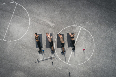 Sportliches Team beim Training, Arme heben, lizenzfreies Stockfoto