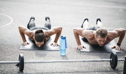 Sportive man and woman during pushups - HMEF00159