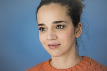 Portrait of smiling woman against blue wall - MOEF01851