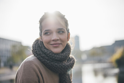 Portrait of smiling woman wearing scarf at backlight stock photo