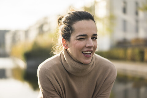 Portrait of winking woman wearing light brown turtleneck pullover in autumn stock photo