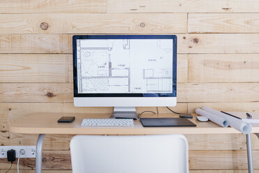 Schreibtisch in einem Heimbüro mit Grundriss auf dem Computer - JRFF02162