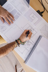 Close-up of architect working at home on floor plan - JRFF02165