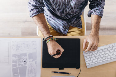 Close-up of man working at home using graphics tablet - JRFF02172