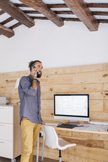 Junger Architekt im Büro zu Hause beim Telefonieren - JRFF02180