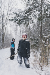 Fröhliche Brüder spielen auf einem verschneiten Feld - CAVF57982