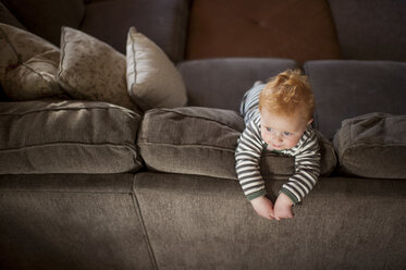 Hohe Winkel Ansicht der niedlichen Baby-Junge schaut weg, während stehend auf Sofa zu Hause - CAVF58046