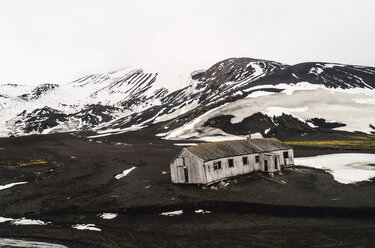 Hohe Winkel Ansicht des verlassenen Hauses auf Landschaft gegen Himmel im Winter - CAVF58073