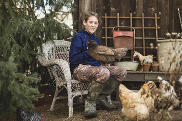 Porträt eines Jungen mit Hühnern auf einem Geflügelhof - CAVF58074