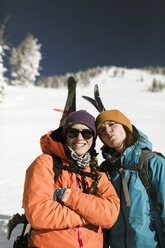 Portrait of friends standing on snow covered mountain against clear sky - CAVF58081