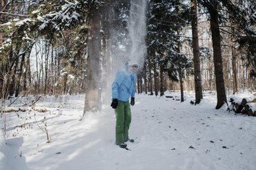 Man standing on snow covered field in forest - CAVF58089