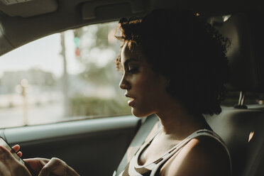 Close-up of woman using smart phone while sitting in car - CAVF58152
