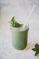 Close-up of smoothie with mint leaves and cacao nibs in mason jar on table - CAVF58178