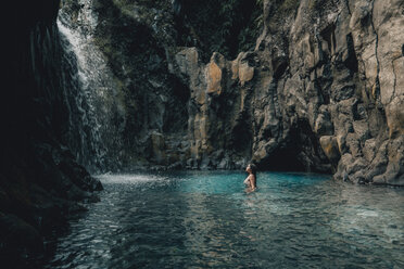 Woman swimming in river by mountain - CAVF58237