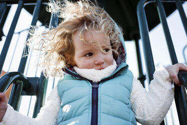 Low angle view of girl playing on slide at playground - CAVF58243