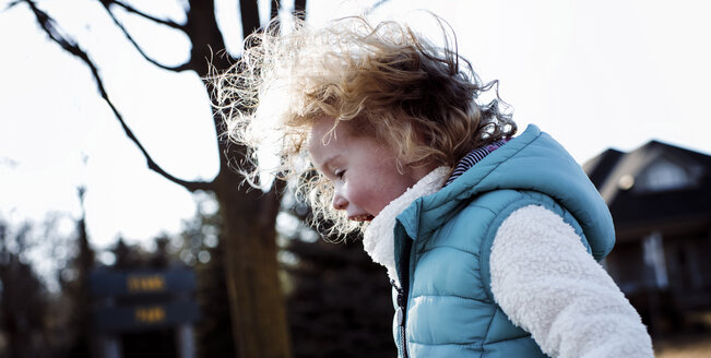 Side view of girl standing at park against clear sky - CAVF58244