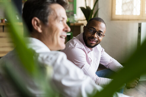 Two businessmen having a discussion in loft office - GIOF04963