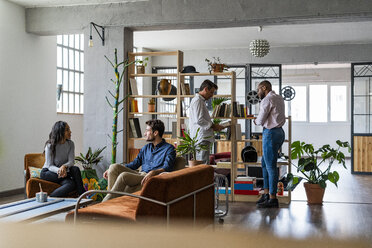 Business team having an informal meeting in loft office - GIOF04965