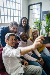 Happy business team taking a selfie in loft office - GIOF05012