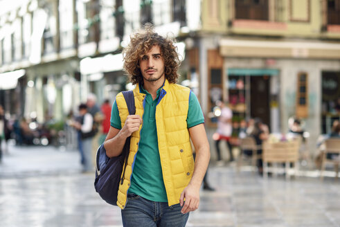 Spanien, Granada, Porträt eines jungen Touristen mit Rucksack, der die Stadt erkundet - JSMF00679