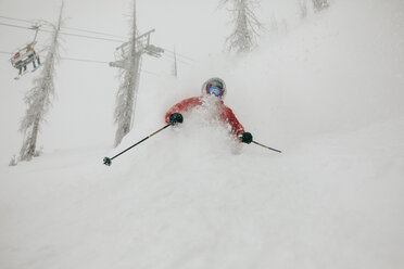Mann beim Skifahren auf einem schneebedeckten Berg im Wald - CAVF58290
