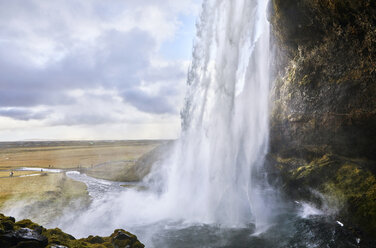 Scenic view of Seljalandsfoss Waterfall against cloudy sky - CAVF58336