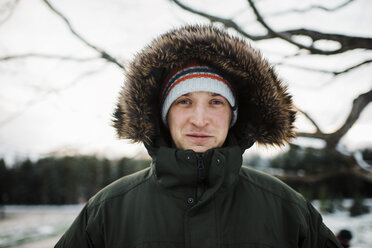 Portrait of man in warm clothing standing against sky during winter - CAVF58345