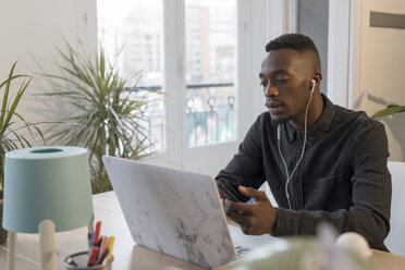 Portrait of young businessman working at desk in the office - GRSF00028