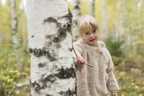 Porträt eines blonden Mädchens, das im Birkenwald spielt, lizenzfreies Stockfoto