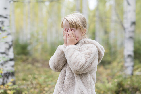 Blondes Mädchen spielt Verstecken in einem Wald - PSIF00181