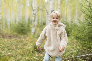 Porträt eines lachenden blonden Mädchens, das im herbstlichen Wald spielt - PSIF00183