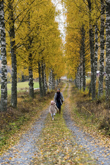 Finnland, Kuopio, Mutter und kleine Tochter gehen im Herbst spazieren - PSIF00187