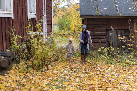 Finnland, Kuopio, Mutter und kleine Tochter spielen zusammen im Herbst, lizenzfreies Stockfoto
