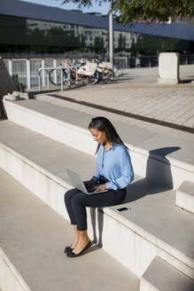 Geschäftsfrau mit Laptop, auf einer Treppe sitzend - MAUF01842