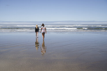 Rückansicht von Mädchen, die am Strand gegen den Himmel laufen - CAVF58467