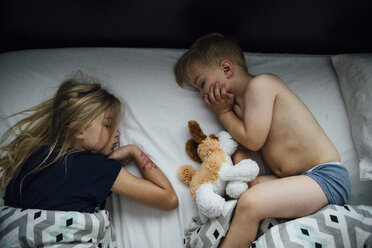 High angle view of siblings sleeping on bed at home - CAVF58501