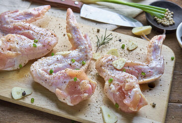 Hohe Winkel Ansicht von Hühnerfleisch mit Gewürz auf Schneidebrett am Tisch - CAVF58511